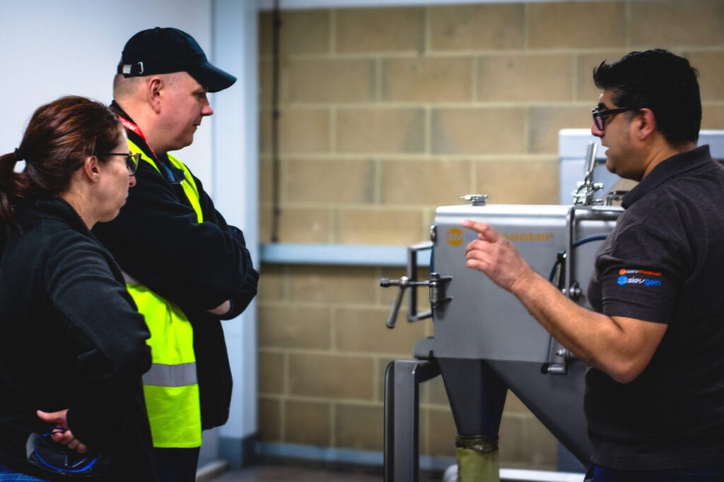 Rehan Tariq demonstrating a Farleygreene Sievmaster Rota 180-C industrial sieve to customers during a product walkthrough